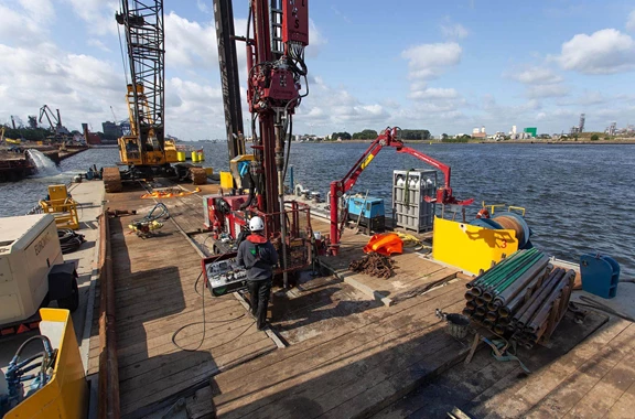 Taking sediment samples from a barge using the SRS-ML sonic drilling rig.